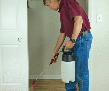 Man doing his own pest control in his house. He is not wearing the proper safety equipment.